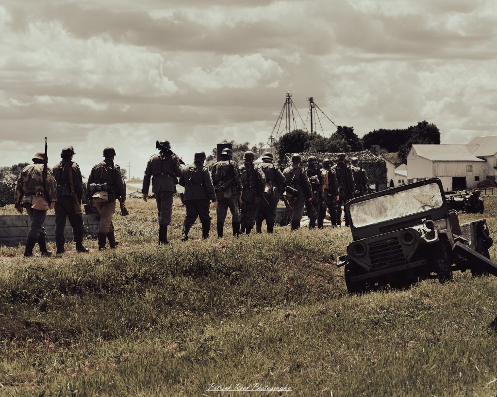 Documentary photographs of World War II reenactors at the Steam Railroading Institute, featuring authentic military uniforms, vintage trains, historical equipment, and living history demonstrations.