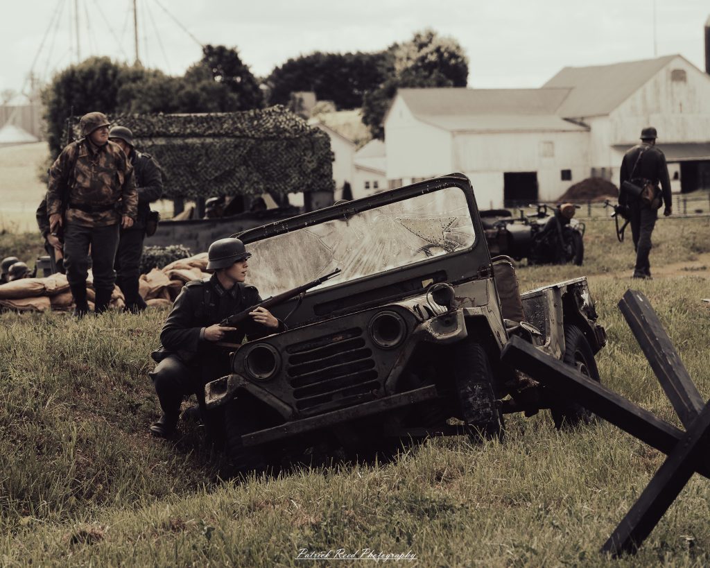 Documentary photographs of World War II reenactors at the Steam Railroading Institute, featuring authentic military uniforms, vintage trains, historical equipment, and living history demonstrations.