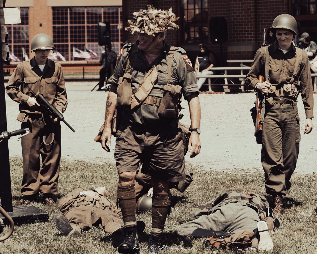 Documentary photographs of World War II reenactors at the Steam Railroading Institute, featuring authentic military uniforms, vintage trains, historical equipment, and living history demonstrations.