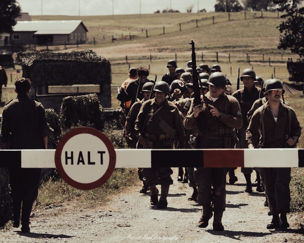 Documentary photographs of World War II reenactors at the Steam Railroading Institute, featuring authentic military uniforms, vintage trains, historical equipment, and living history demonstrations.