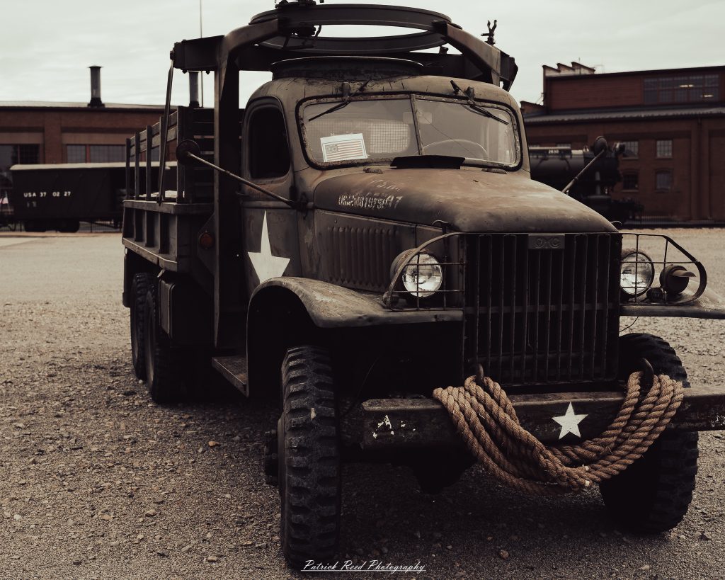 Documentary photographs of World War II reenactors at the Steam Railroading Institute, featuring authentic military uniforms, vintage trains, historical equipment, and living history demonstrations.