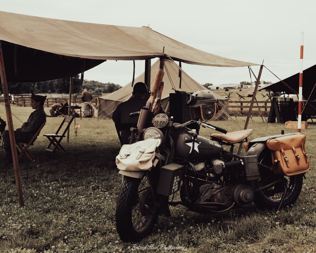 Documentary photographs of World War II reenactors at the Steam Railroading Institute, featuring authentic military uniforms, vintage trains, historical equipment, and living history demonstrations.