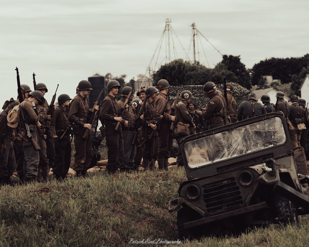 Documentary photographs of World War II reenactors at the Steam Railroading Institute, featuring authentic military uniforms, vintage trains, historical equipment, and living history demonstrations.