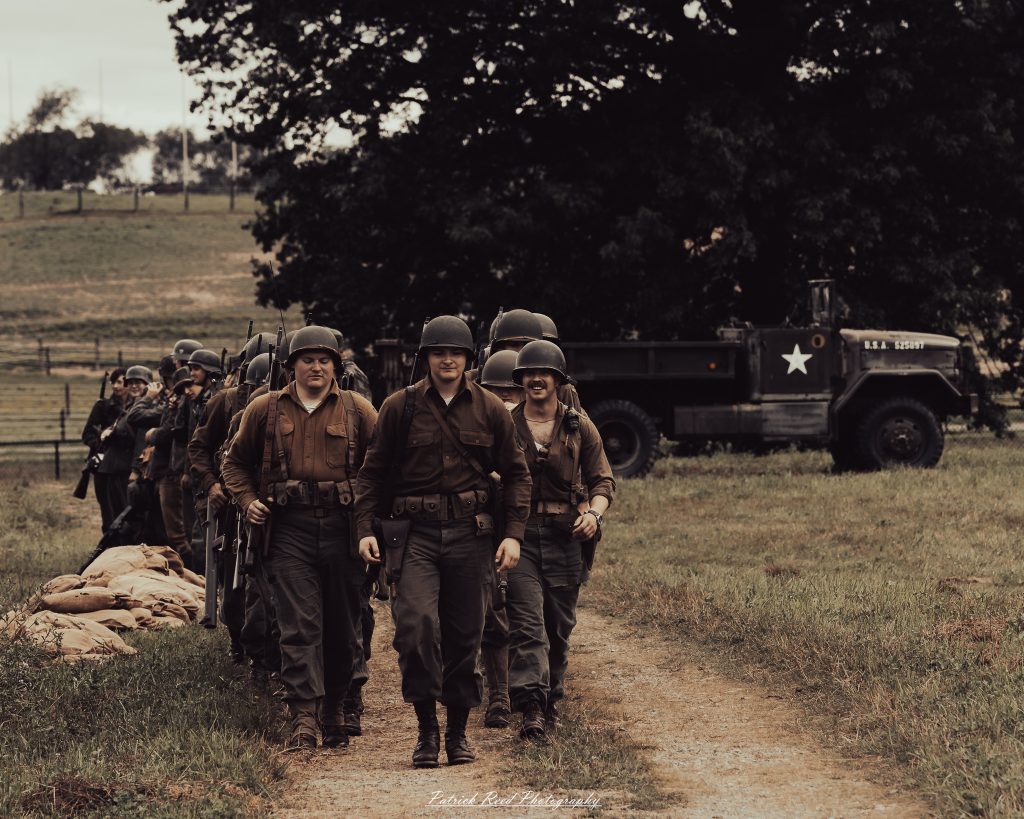 Documentary photographs of World War II reenactors at the Steam Railroading Institute, featuring authentic military uniforms, vintage trains, historical equipment, and living history demonstrations.