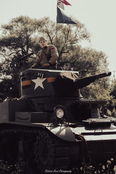 A group of World War II reenactors in period-accurate uniforms—American, German, and French Resistance—on a sandy shore during the D-Day Conneaut 2025 reenactment at Conneaut Township Park, Ohio.