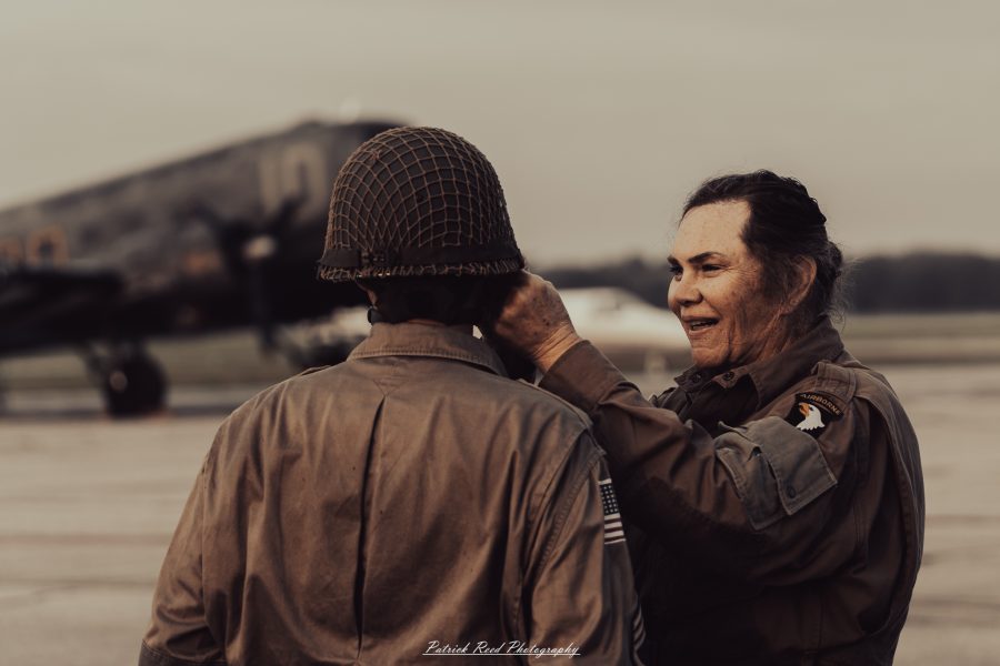 A group of World War II reenactors in period-accurate uniforms—American, German, and French Resistance—on a sandy shore during the D-Day Conneaut 2025 reenactment at Conneaut Township Park, Ohio.
